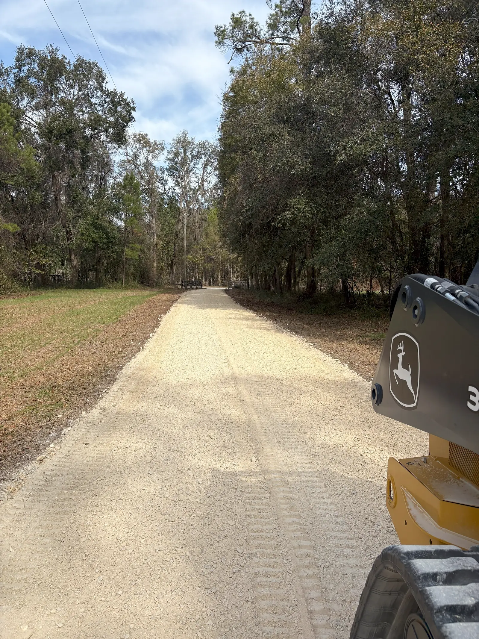 Freshly graded limerock driveway seen from the seat of a John Deere track loader near Starke, Florida